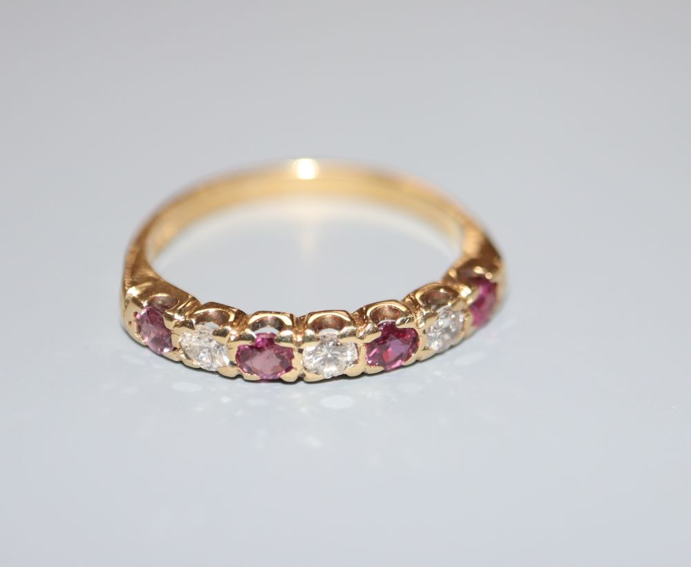 A modern 18ct, three stone diamond and four stone ruby set half hoop ring, size P/Q, gross 3.7 grams.
